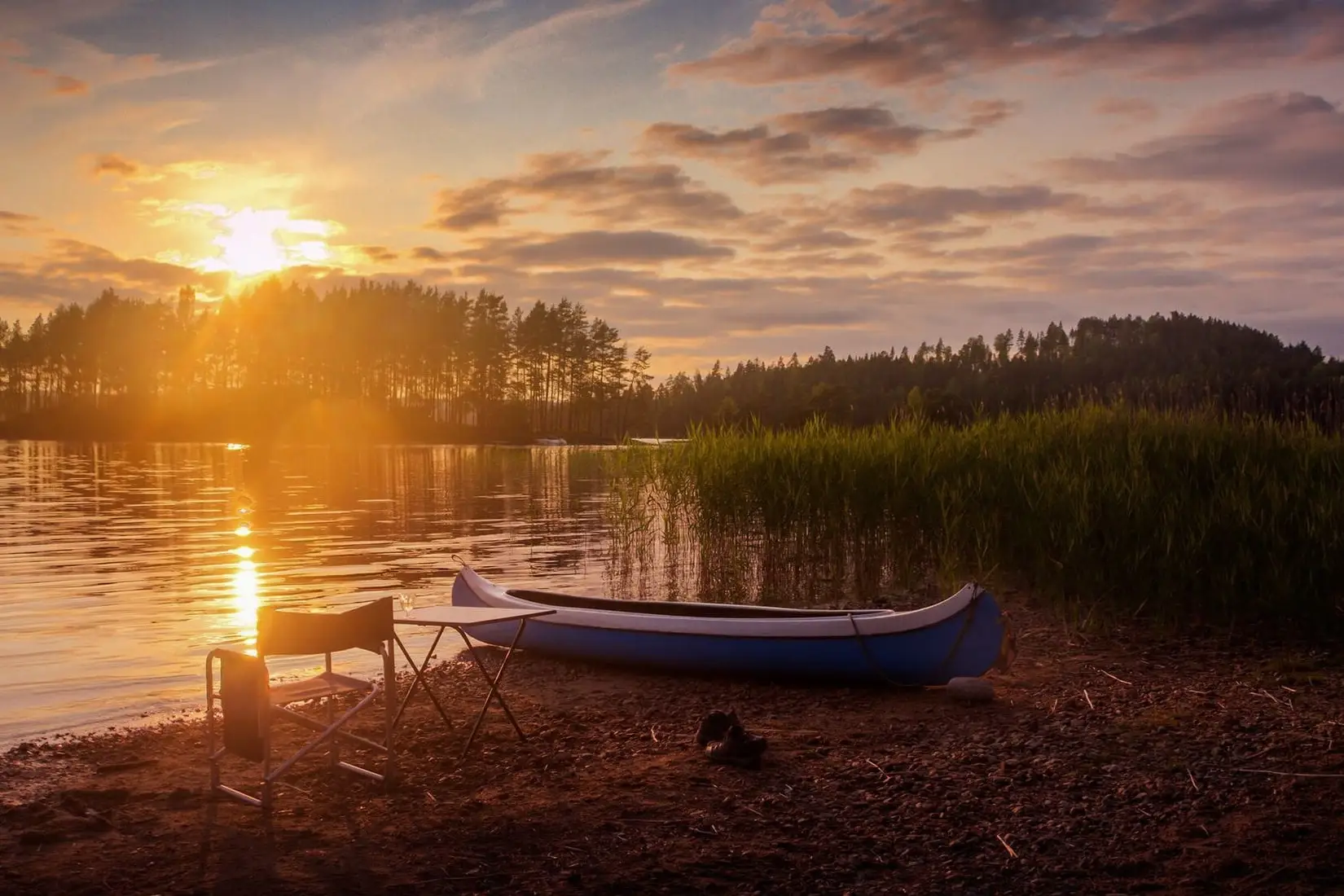 Een kano op de oever van een meer bij zonsondergang
